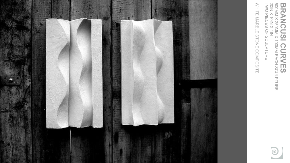 Two white marble sculptural pieces with curved grooves, mounted on a wooden wall.