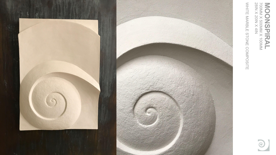 A white, textured, spiral-shaped architectural element or wall sculpture on a light-colored wall.