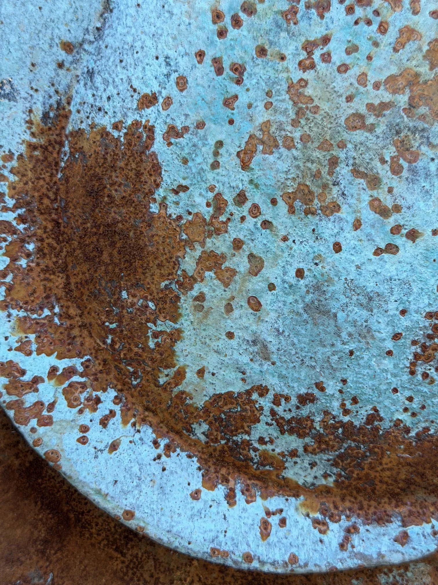 Close detail of the Moon Crater Phase Blue Wall Sculpture, rust flecks scattered over a blue ground
