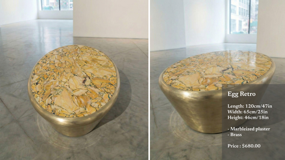 A marble and brass retro styled egg-shaped table with a marble top and brass base, displayed in an art gallery space.