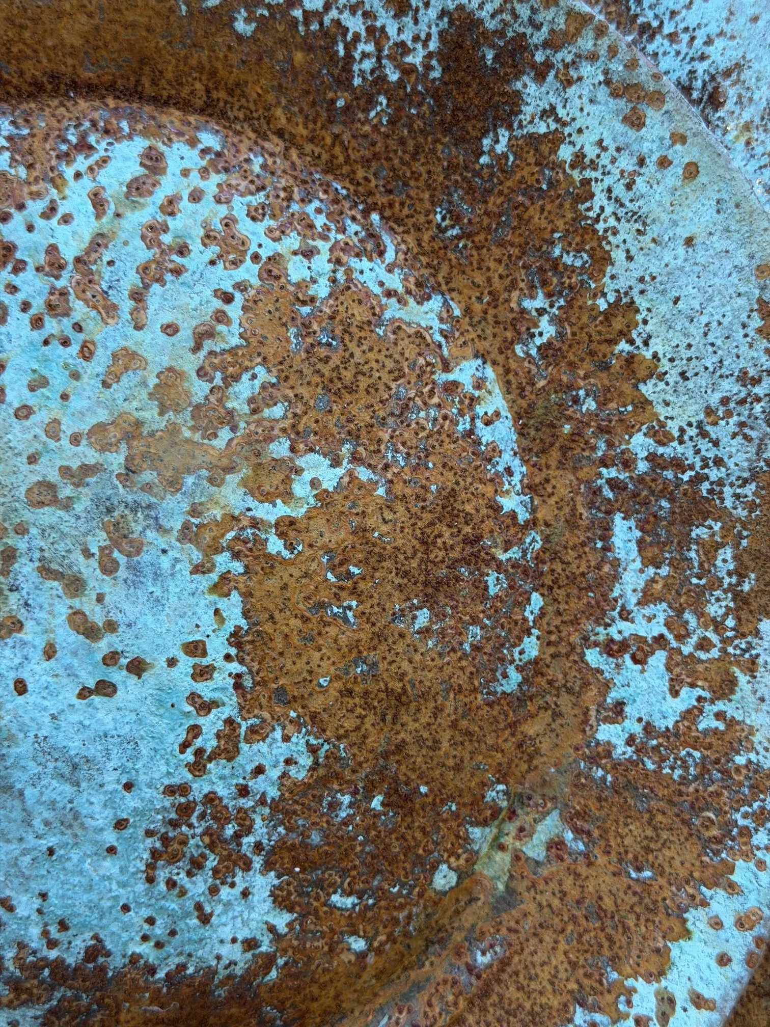 Close detail of the Moon Crater Phase Blue Wall Sculpture surface, rust spreading across the blue crater