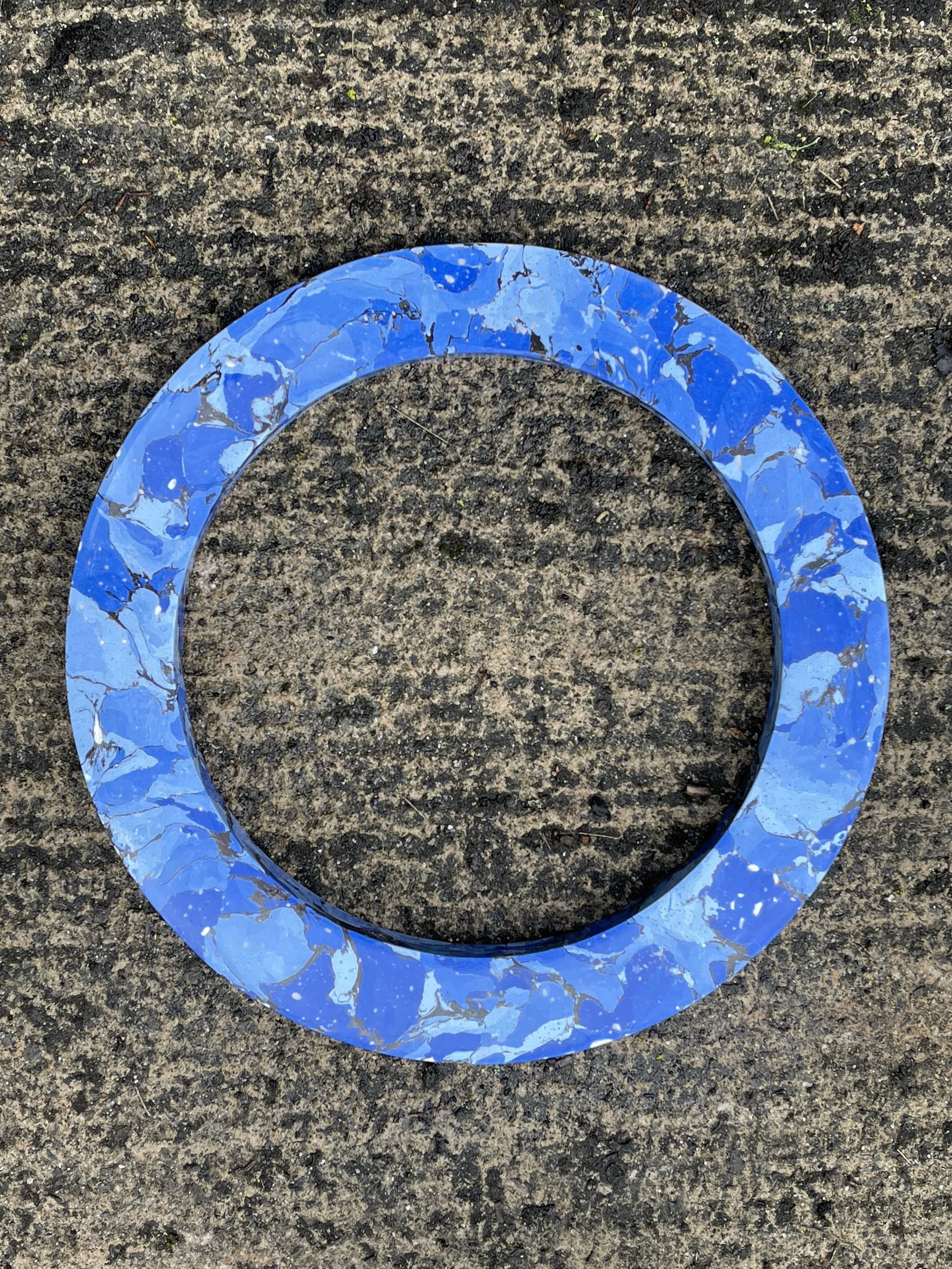 Wet Ocean Marble Mirror frame seen from above, the blue marbled ring on a textured surface
