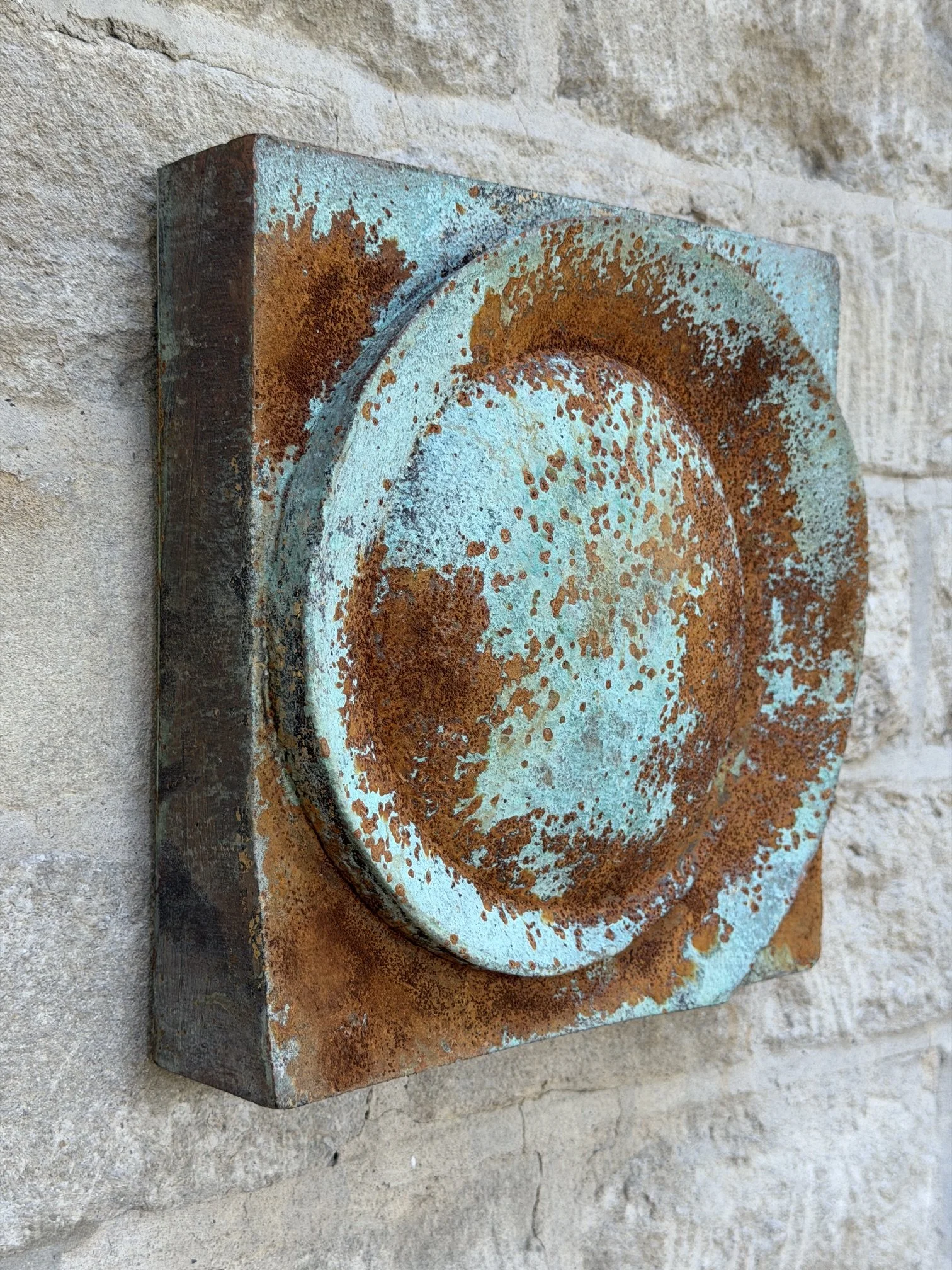 Moon Crater Phase Blue Wall Sculpture seen at an angle, the rusted crater disc standing proud of its panel