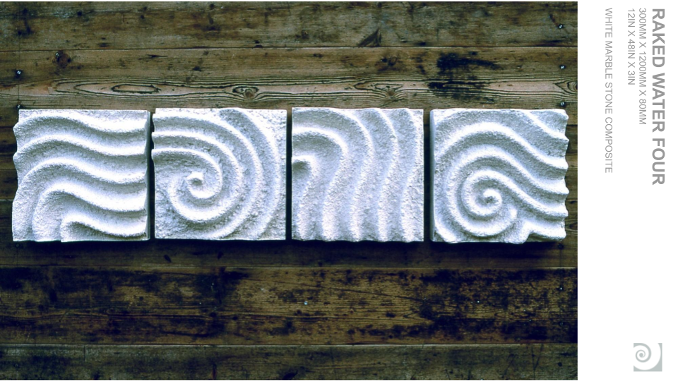 Four white textured stone tiles with spiral patterns arranged in a row on a wooden surface.