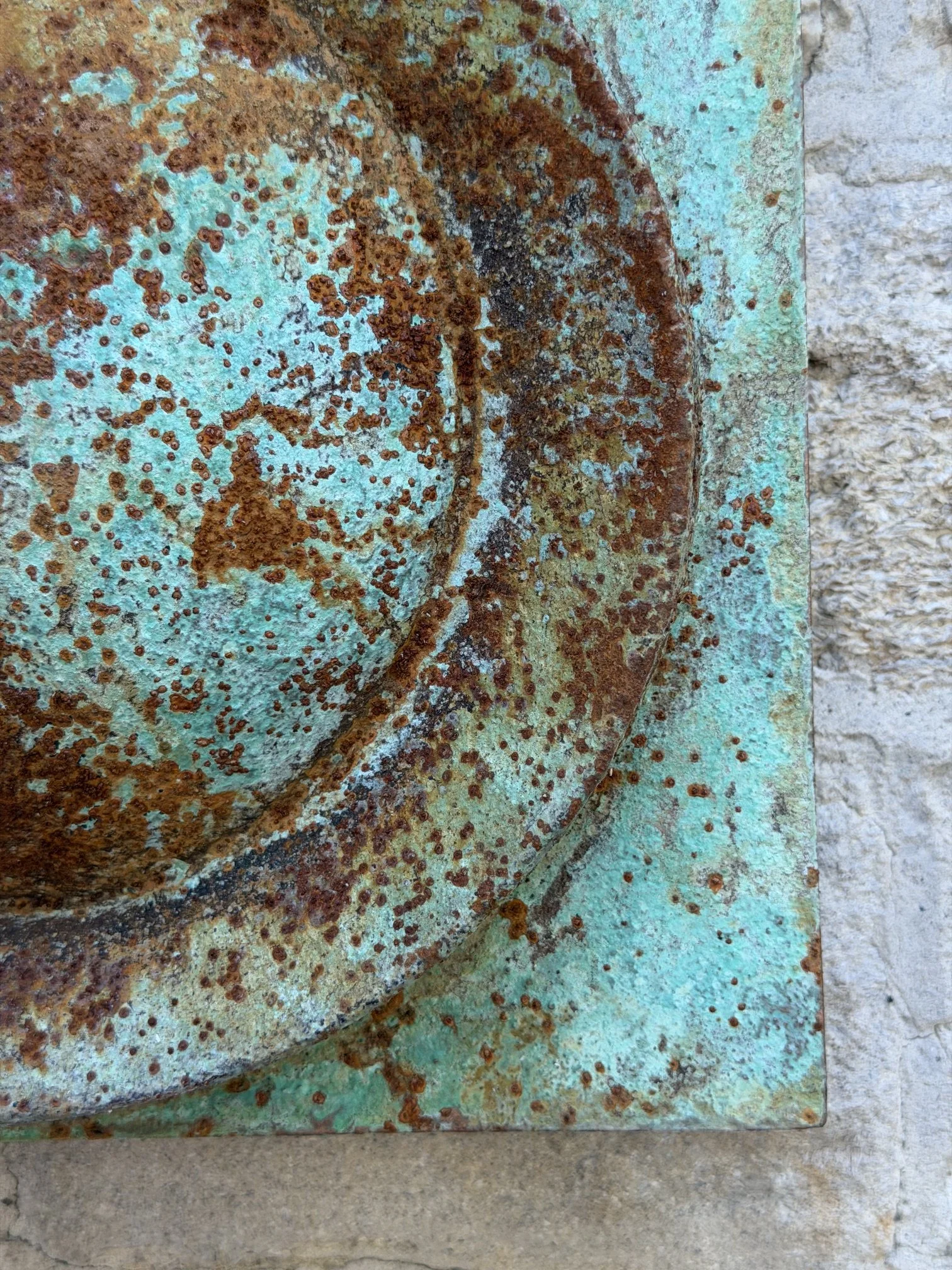 Close detail of the Moon Crater Phase Verdigris Spherical Wall Sculpture surface, rust over green verdigris
