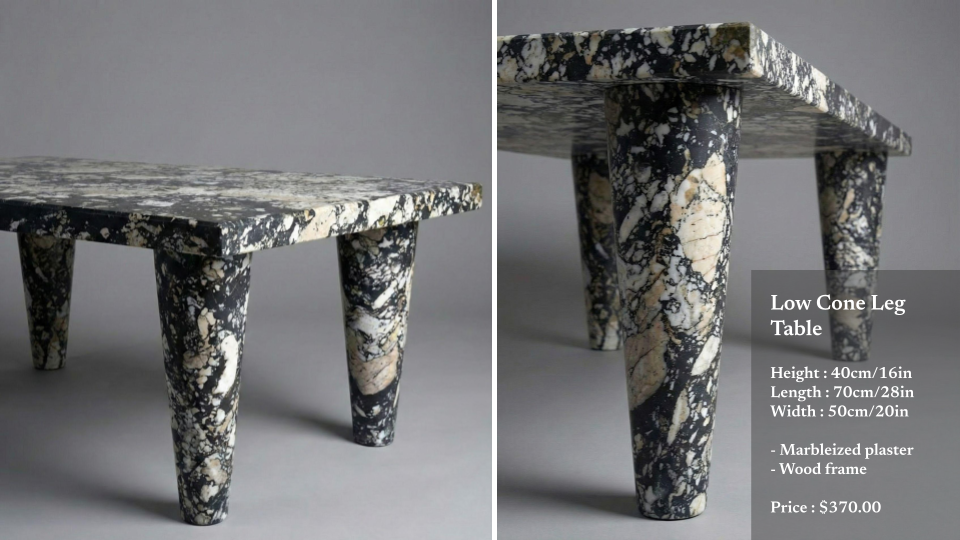 A small, low table with a marbleized plaster top and wooden cone-shaped legs, featuring a black and white pattern.