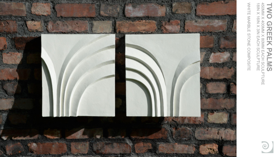 Two white marble sculptures mounted on a brick wall, each featuring curved grooves resembling rainbows or arches.