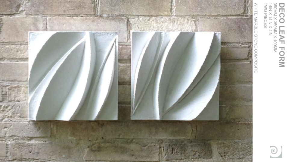 Two white marble stone wall plaques with carved abstract wave patterns, mounted on a textured brick wall.
