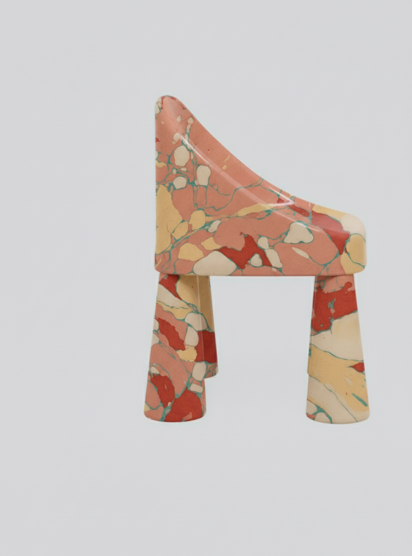 A chair with a colorful, abstract marbled pattern in shades of red, beige, yellow, and green against a plain white background.