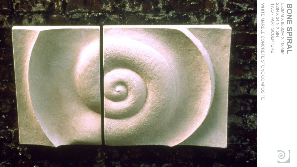 Two rectangular white marble sculptures depicting a spiral shell in a sculpture composition.