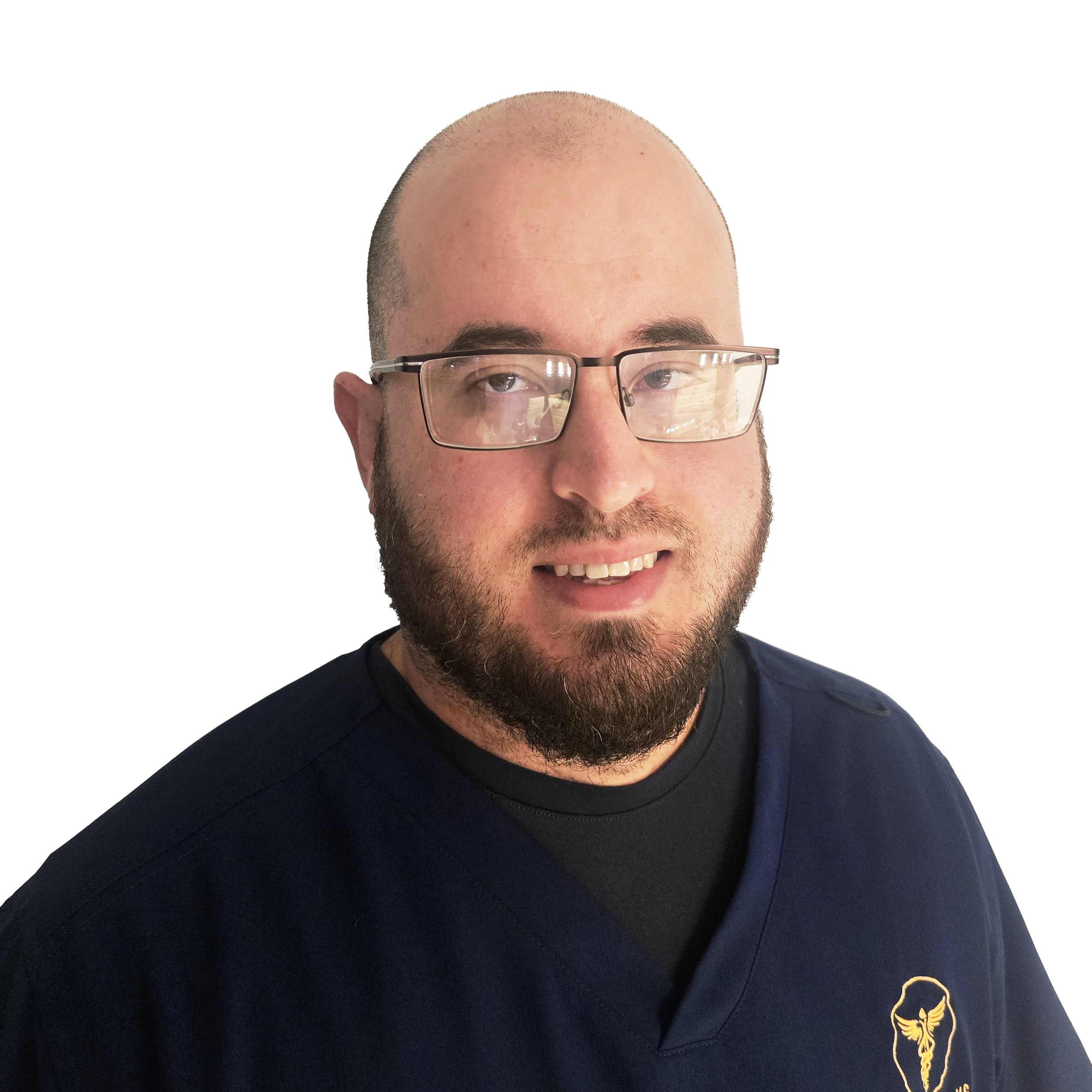 Portrait of a man with glasses, a beard, and a shaved head, wearing a navy blue shirt with a yellow logo on the chest, smiling at the camera.