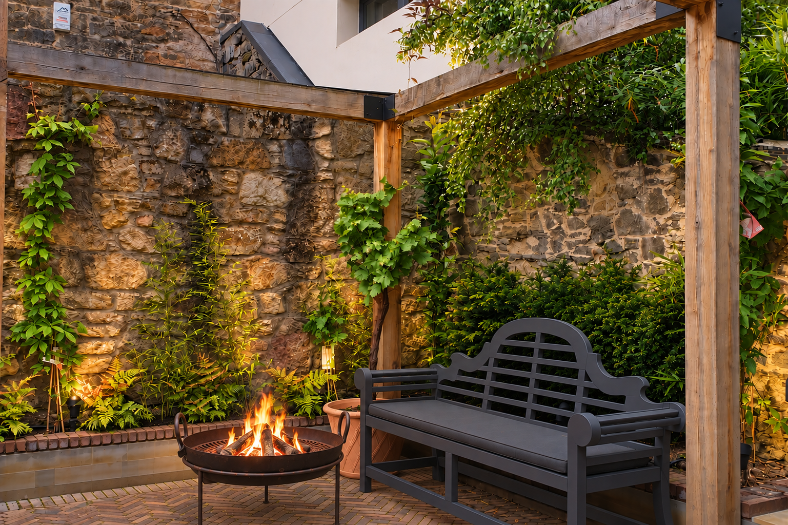 Contemporary garden design with fire pit, built-in seating, planting and feature stone wall.