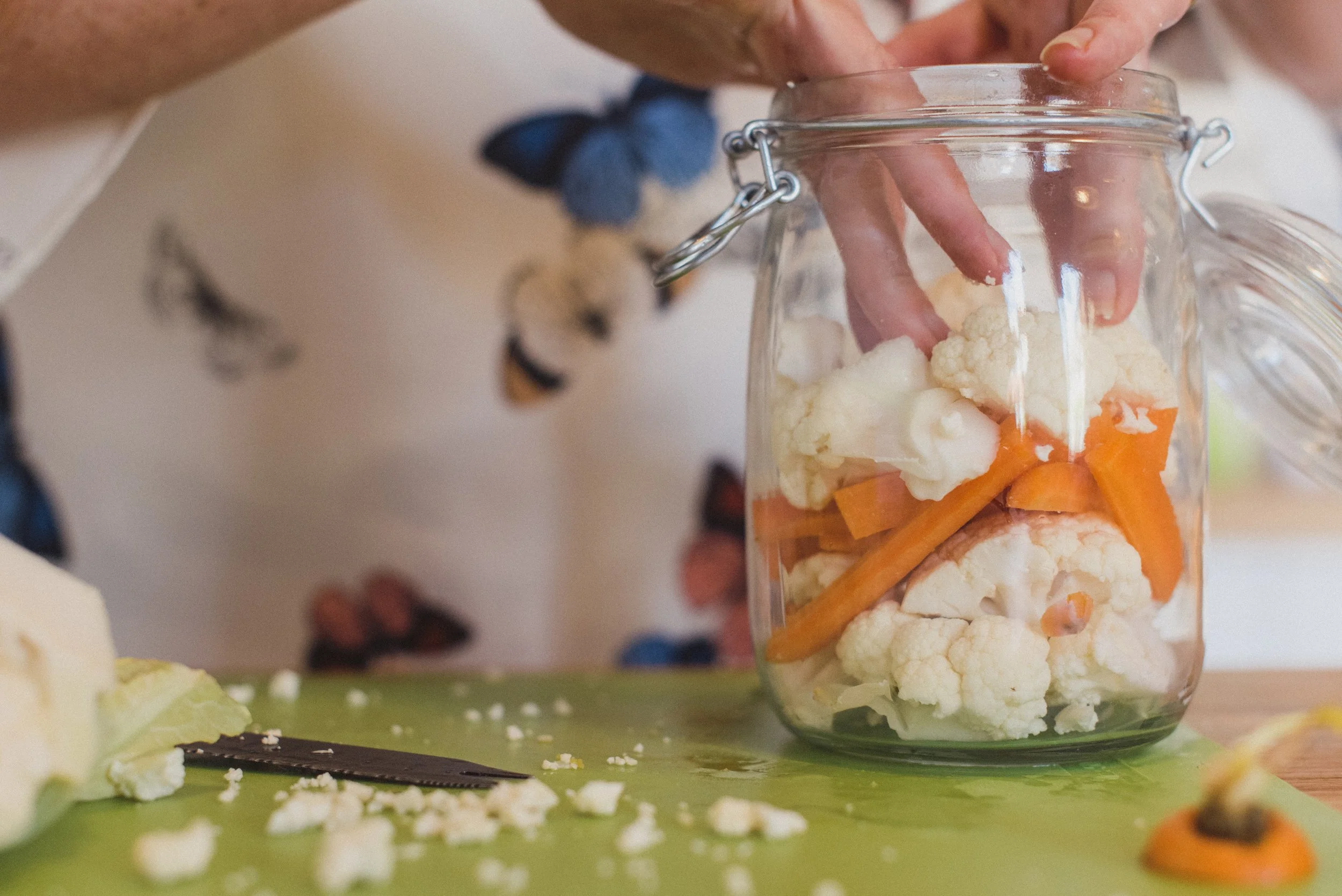 Wendy Hills, Nutritional therapist in Kent, UK chopping cauliflower and carrots in a glass jar.