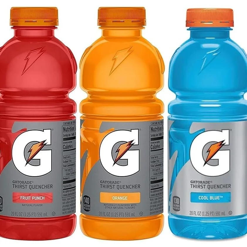 Three Gatorade sports drinks lined up in red, orange, and blue flavors from left to right.