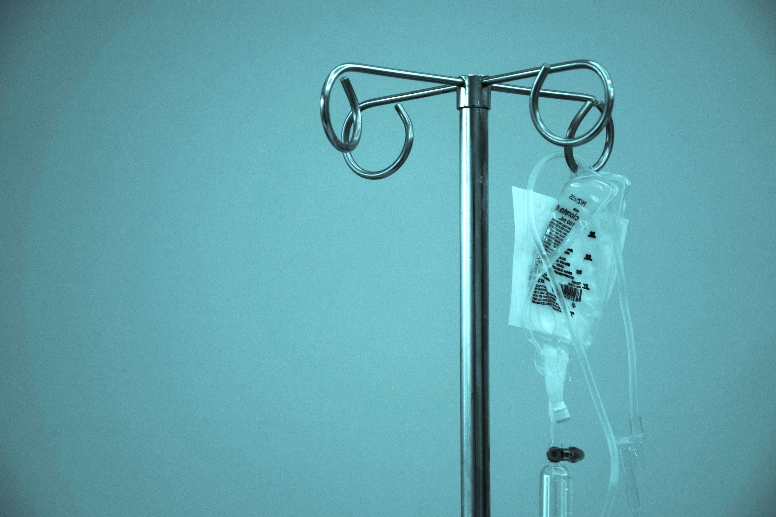 An intravenous vitamin drip bag with a teal colored filter.