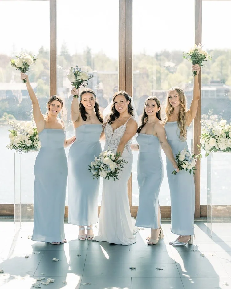 A bride surrounded by her bridesmaids wearing light blue