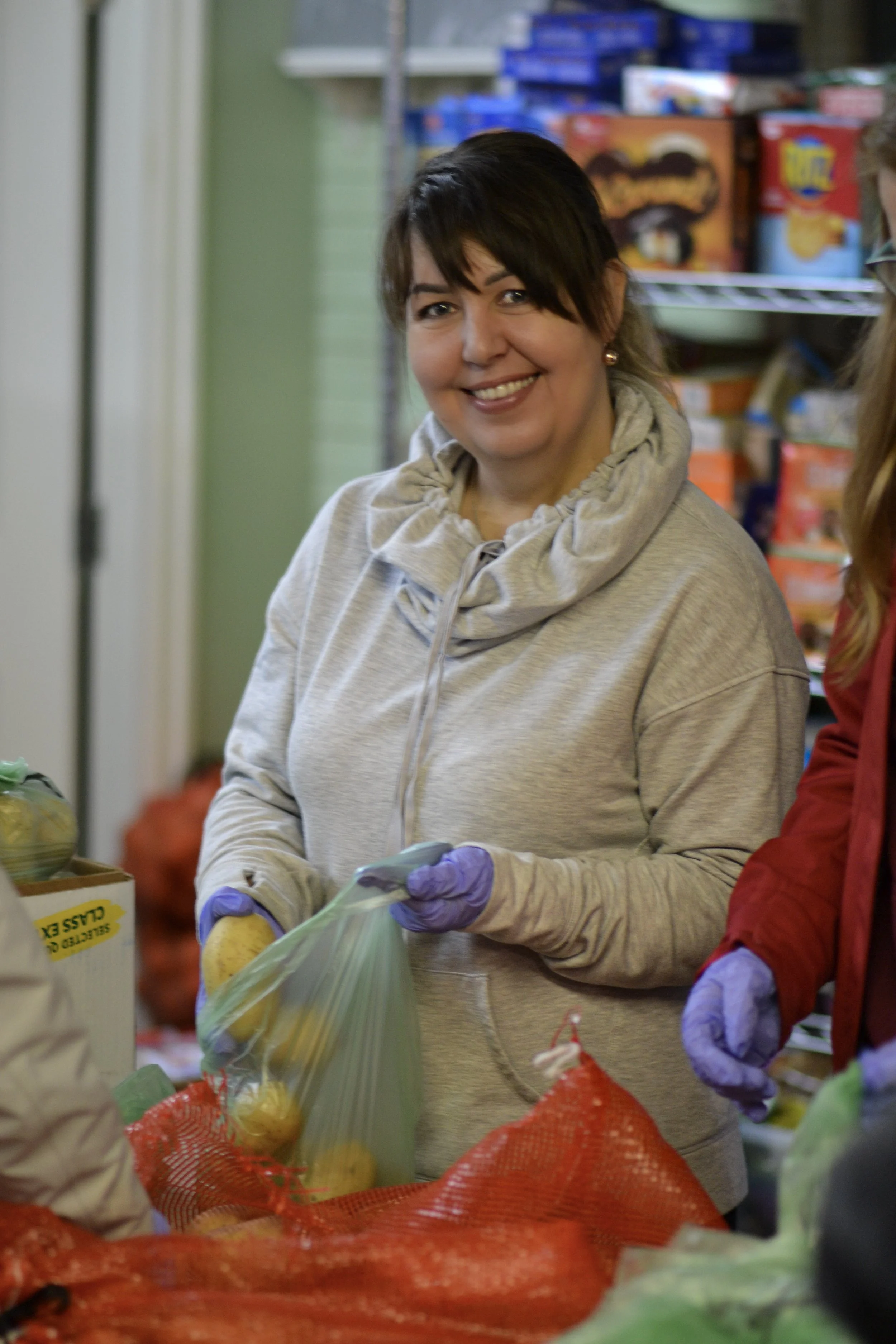 Raphael House volunteer assisting a family during weekly food pickup in Langley