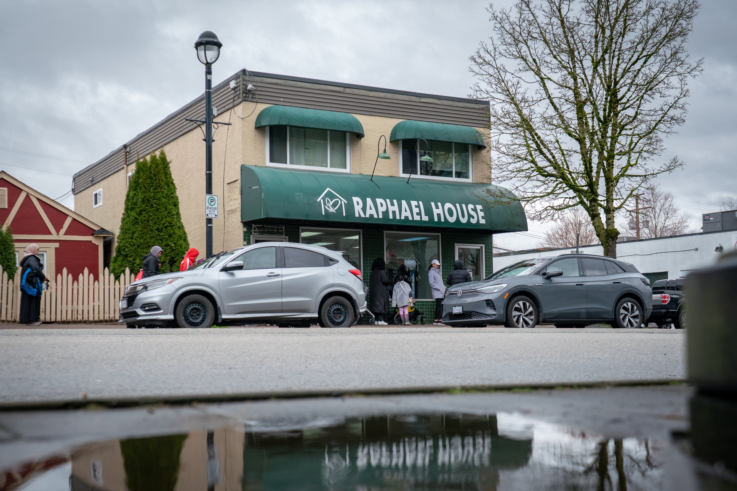 Raphael House volunteer handing groceries to a family in Langley BC