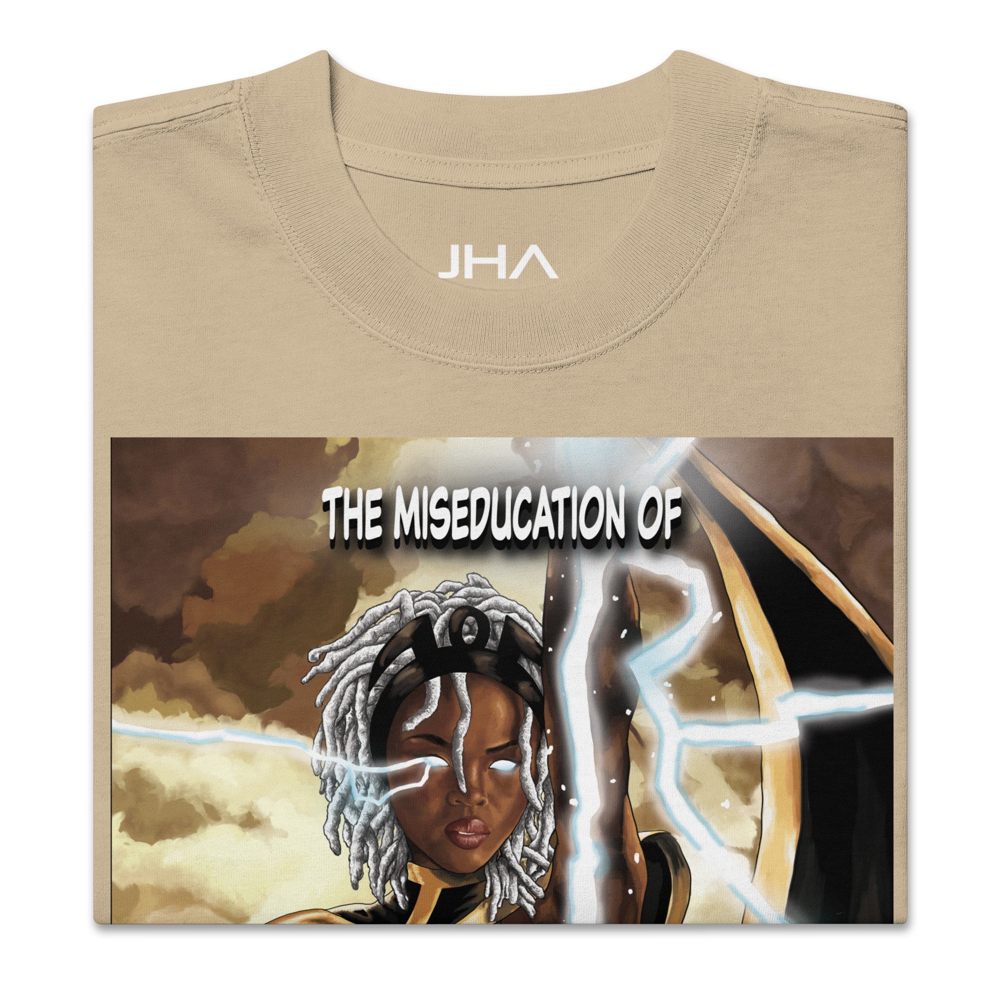 Folded oversized faded beige T-shirt featuring 'The Miseducation of Storm' graphic, showcasing Storm with glowing eyes and lightning details.