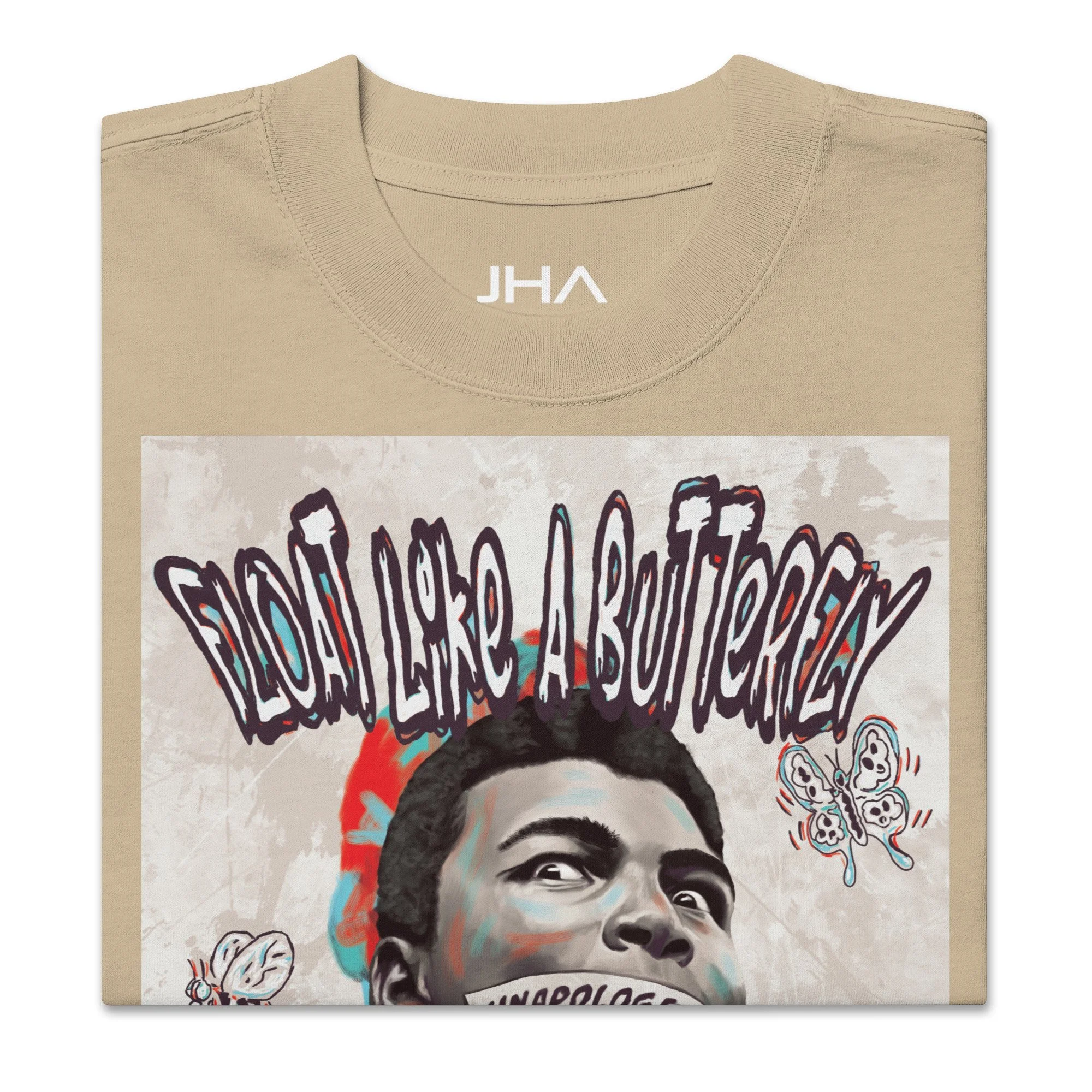 Folded oversized faded beige T-shirt with a Muhammad Ali graphic, featuring 'Float like a butterfly' text and symbolic imagery