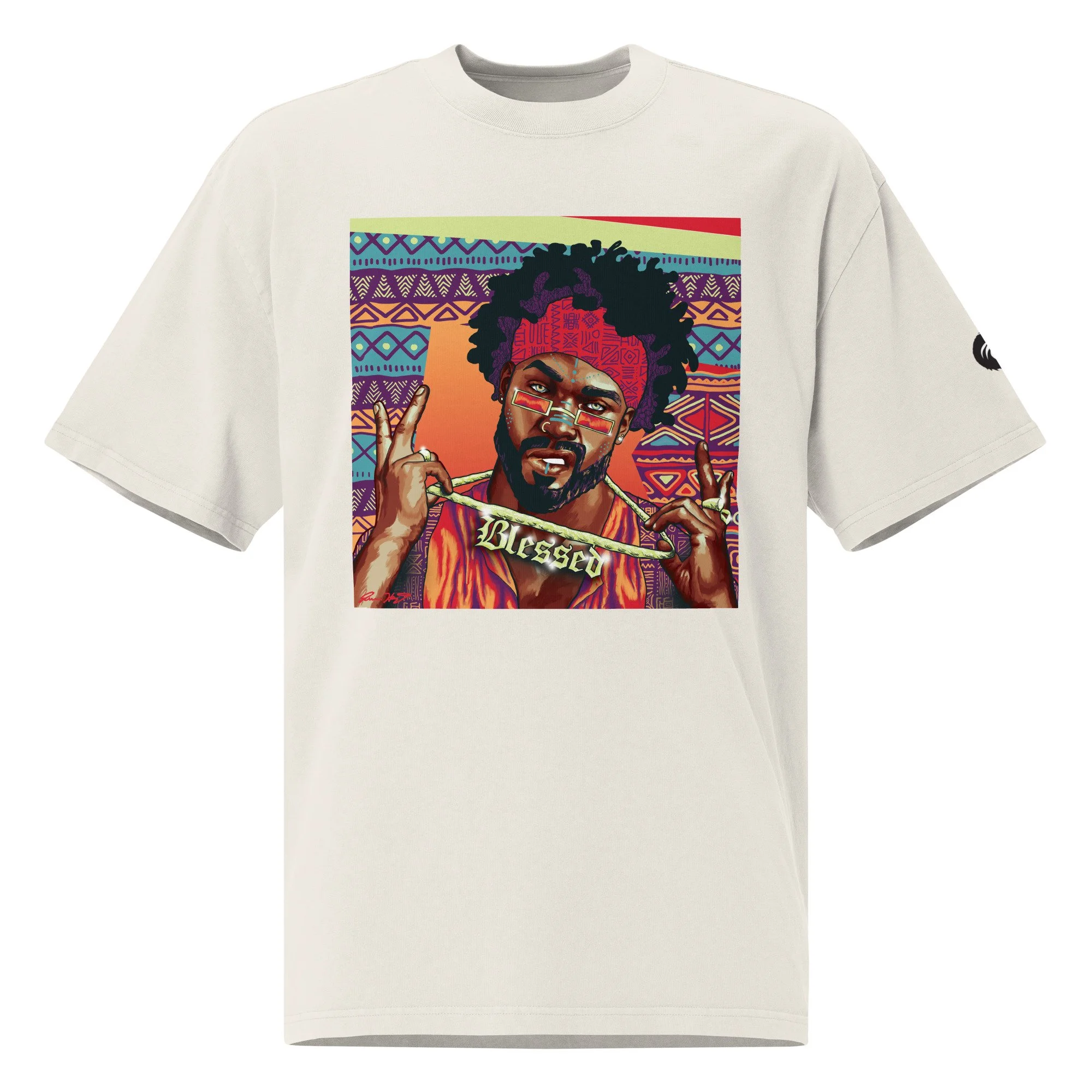 cream tee with a vibrant square print of a Black man wearing a red bandana and glasses, holding a gold “blessed” chain against a colorful geometric backdrop.