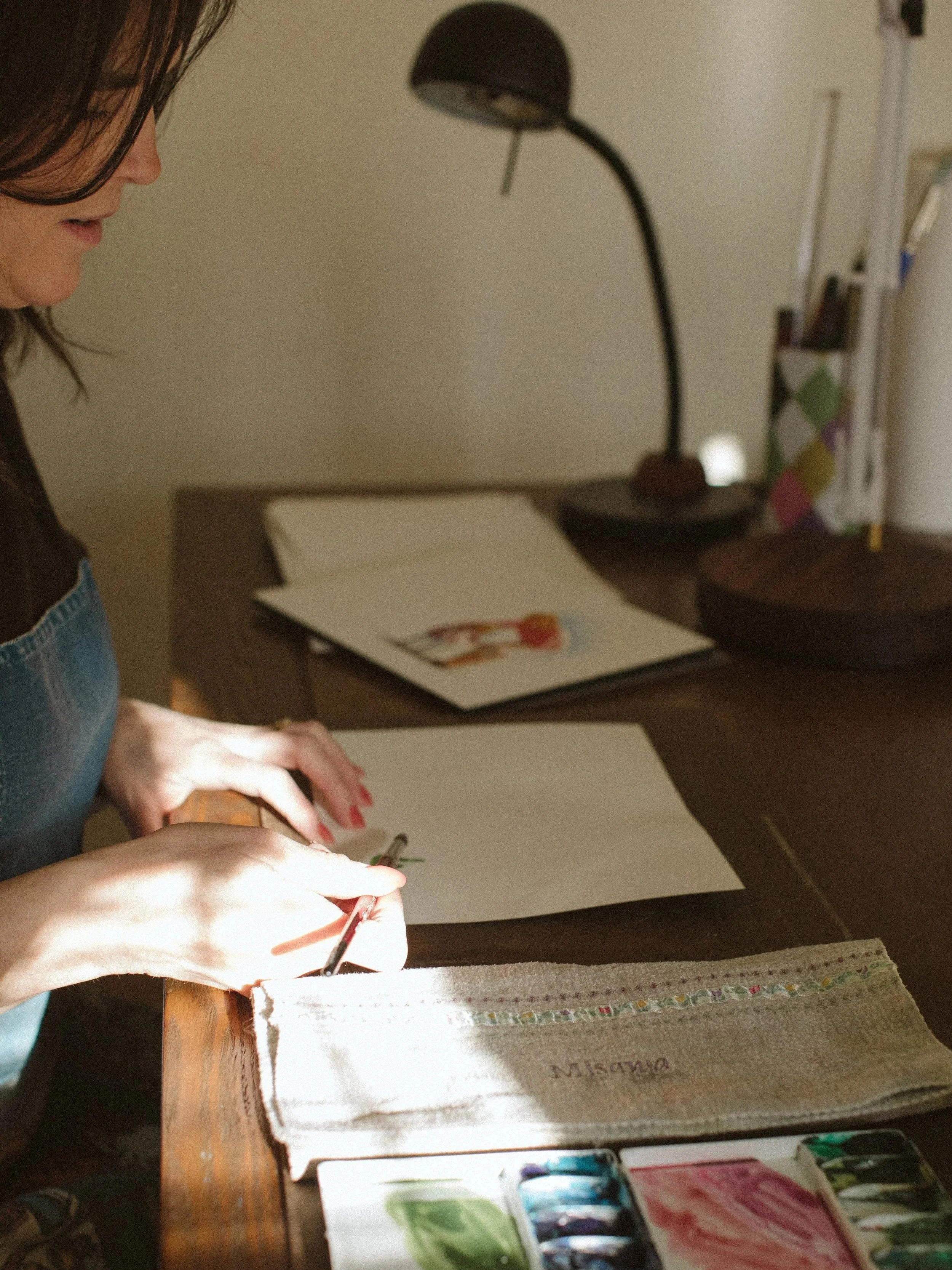 Keri Misawa, watercolor artist in Omaha working on a piece in her studio