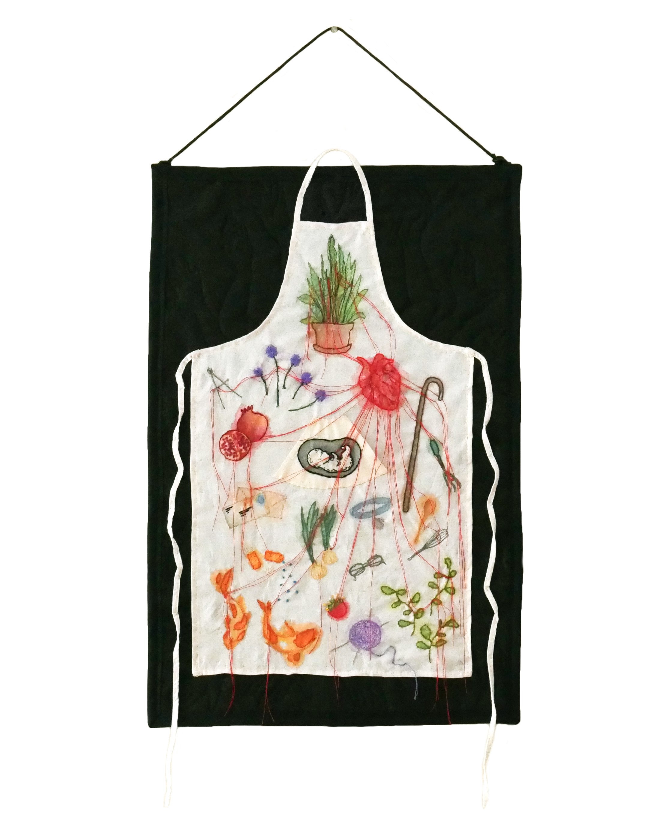 Quilted wall hanging of a white apron on a black background, the apron embroidered with color motifs like flowers, an anatomical heart, koi fish, and a fetus