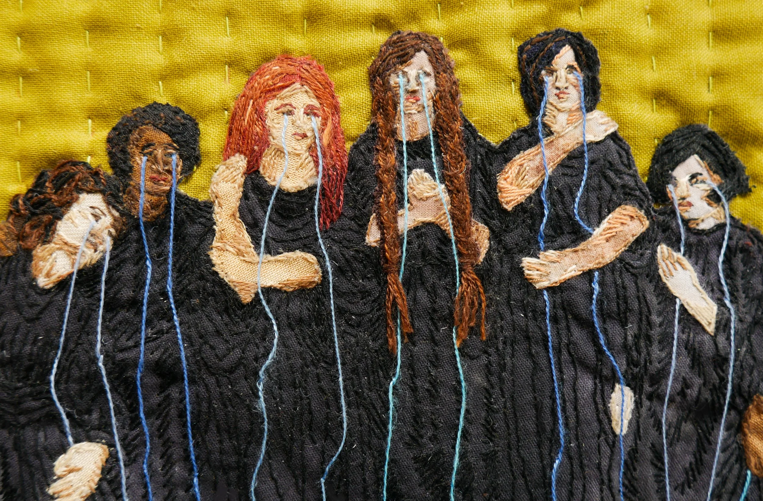 A row of embroidered figures cloaked in black with tears streaming down their faces