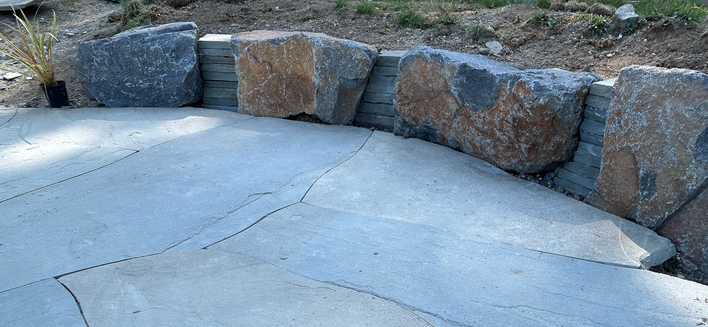 Stone retaining wall with bluestone patio in Gig Harbor crafted by 7 Lamps Construction (Gig Harbor). www.7lamps.com