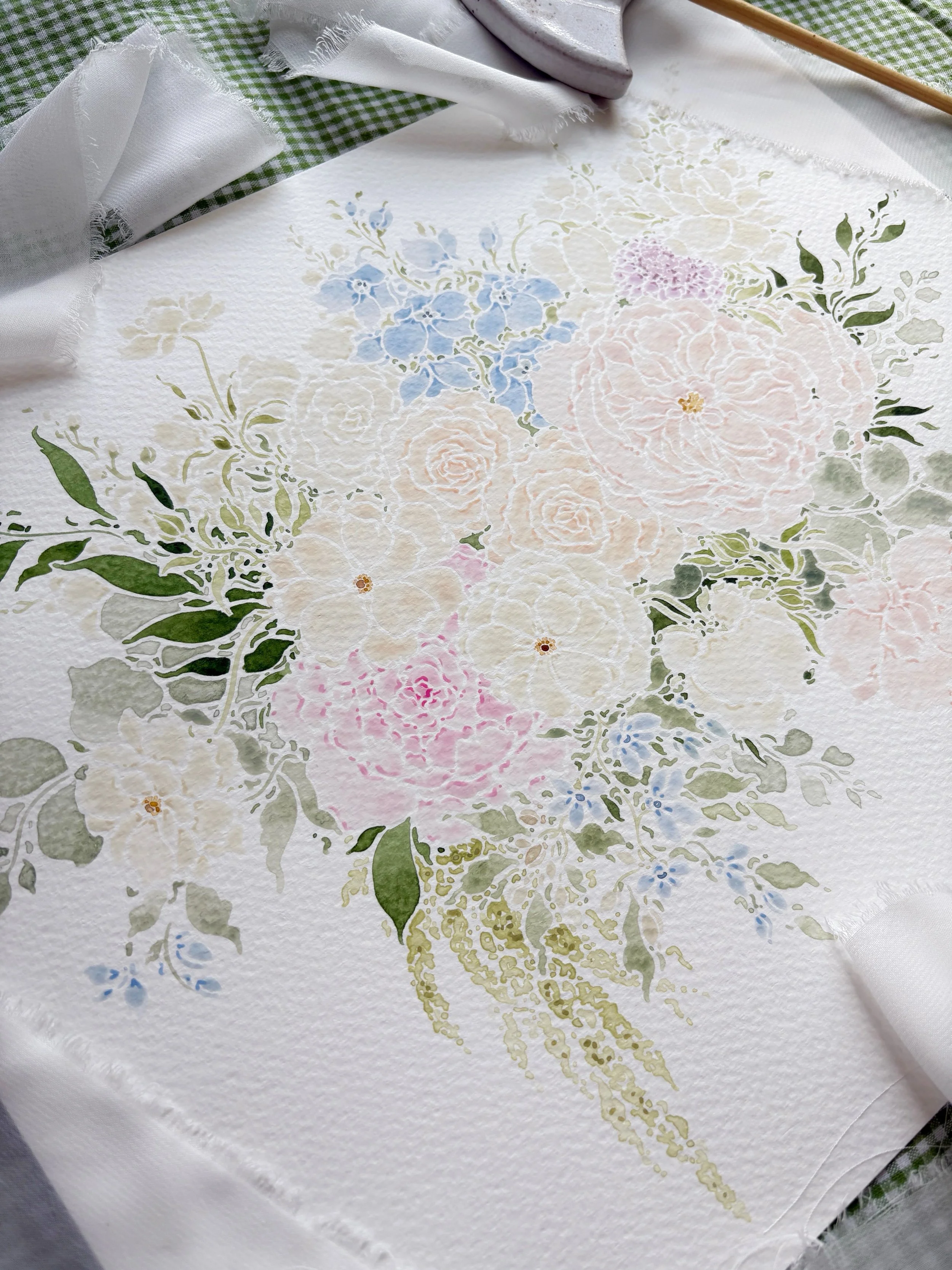 Watercolor floral painting featuring pastel pink roses, blue hydrangeas, and green leaves, with a textured white background and white fabric edges.