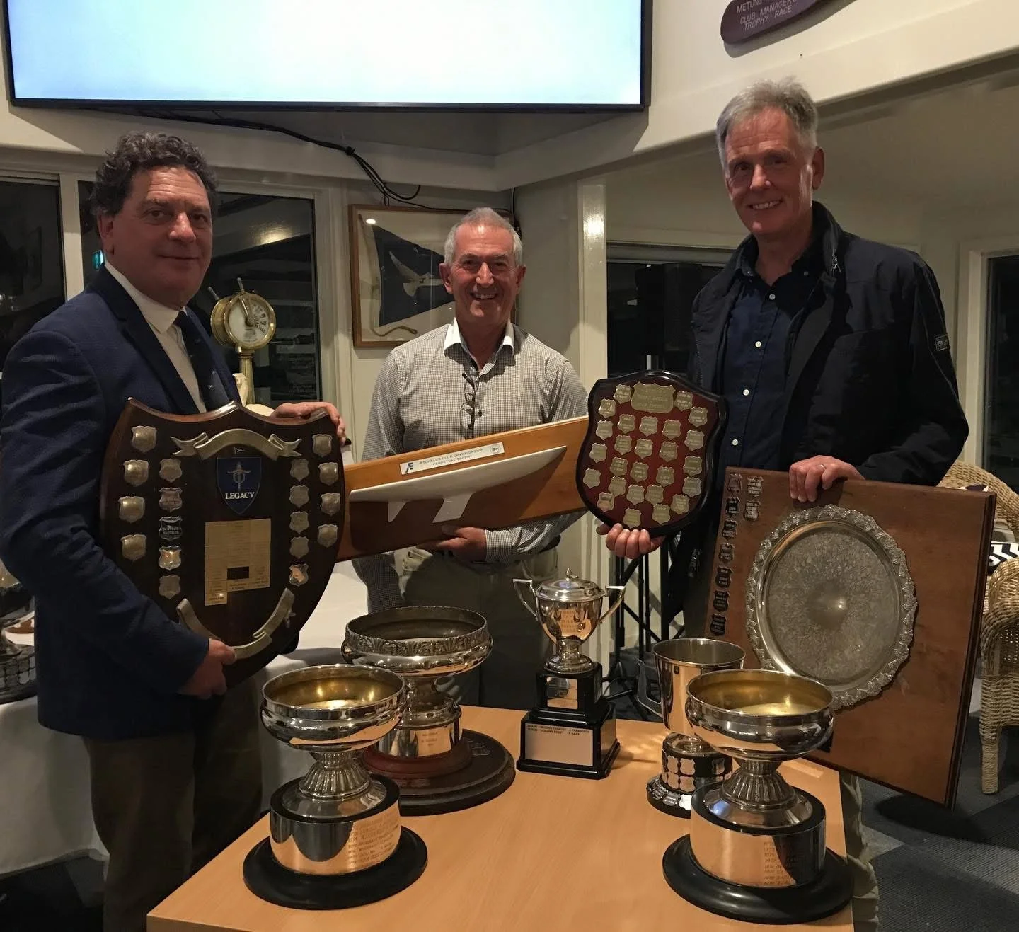 Commodore Peter Kanat helps carry the silverware for Fred Haes (centre), owner of Leading Edge, and one of his crew, Michael Brown. 
Haes and his crew on board Leading Edge were crowned the new Club Champions on Saturday at Metung Yacht Club’s trophy