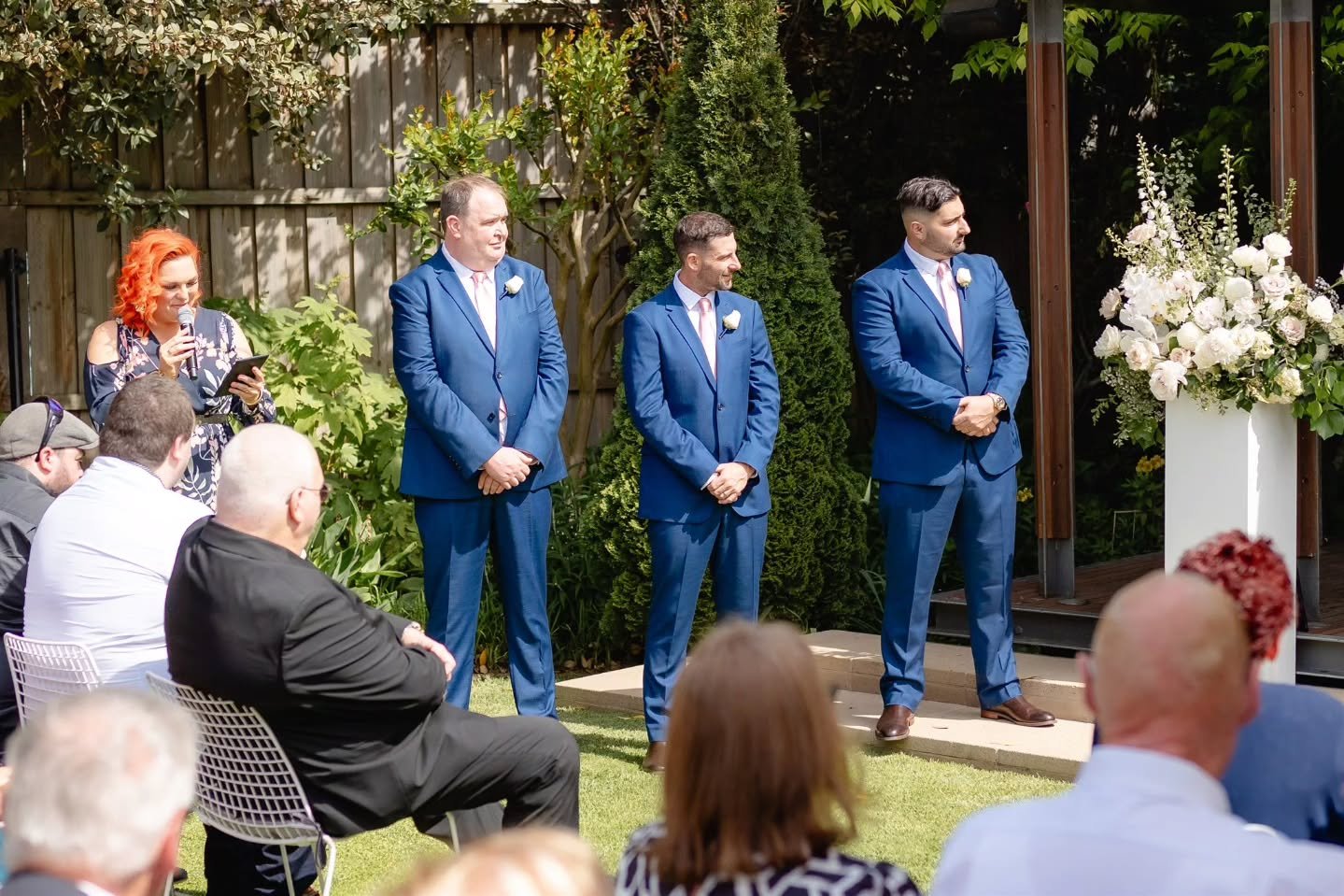 I normally like to stand next to the last Bridesmaid.... as a point of reference for when they are walking down the aisle, especially for the first one...so they know to come and stand right next to me and then I can guide everyone else into position