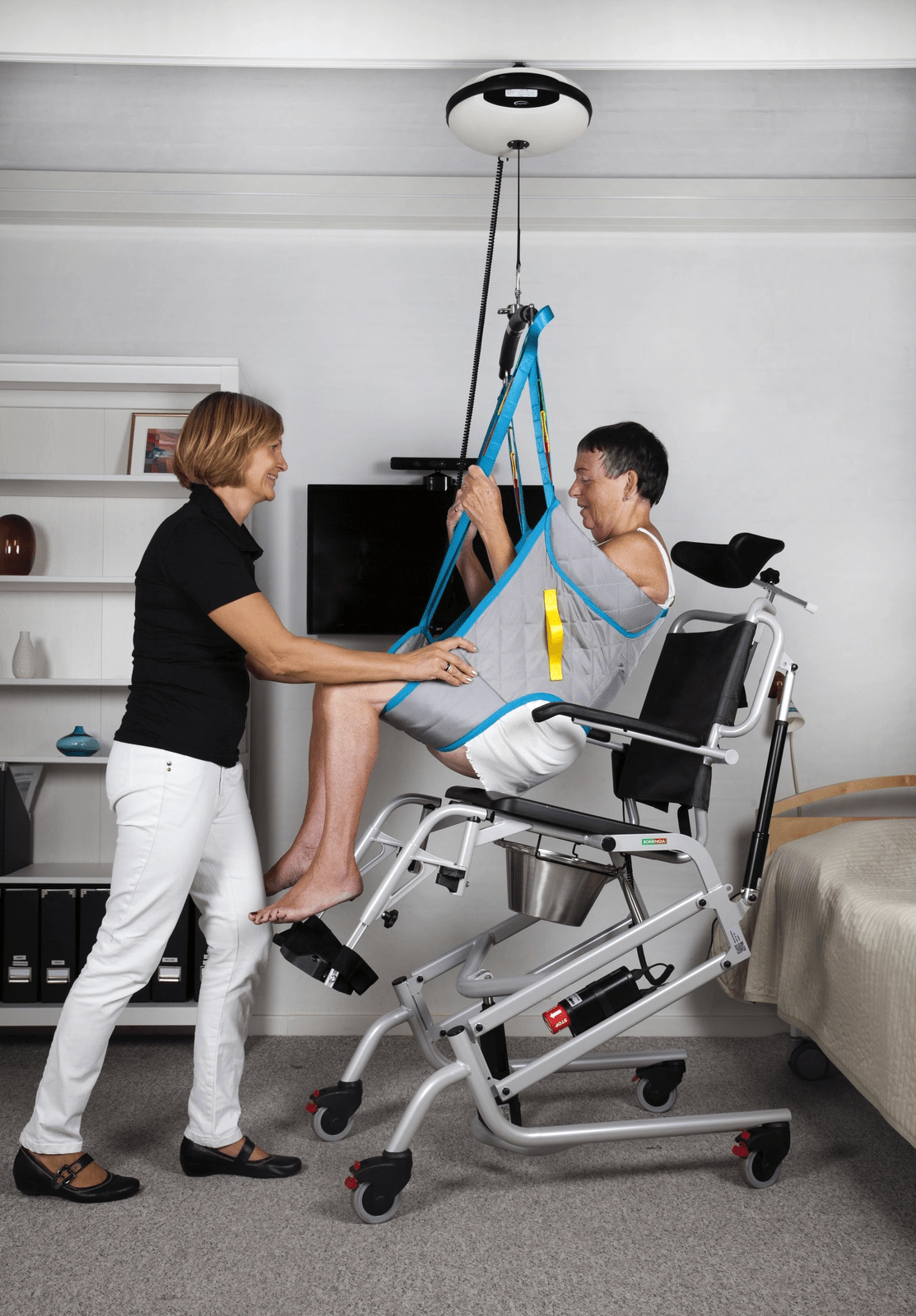 Physiotherapist demonstrating safe manual handling techniques to client in a hoist