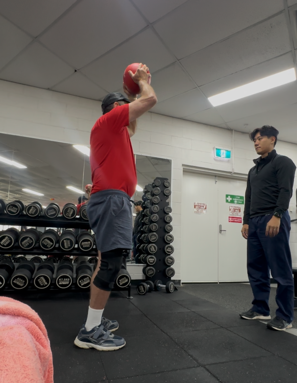 Older adult performing personalised exercises with physiotherapist for falls prevention