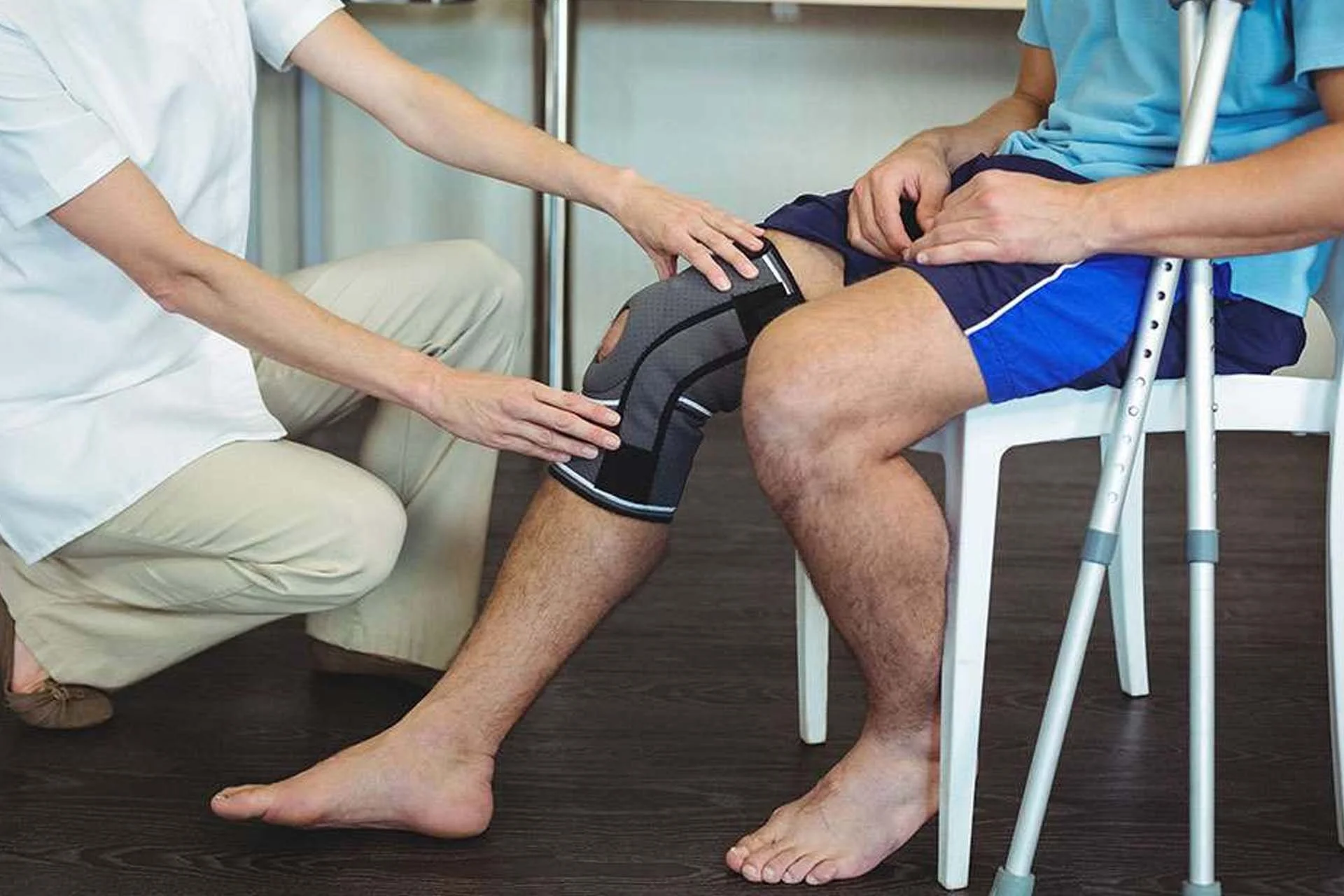 Physiotherapist supporting client with exercises after hip or knee replacement surgery