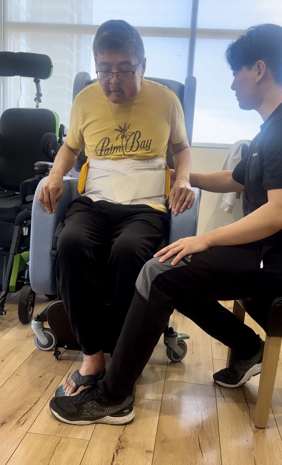 Physiotherapist demonstrating safe manual handling techniques to client