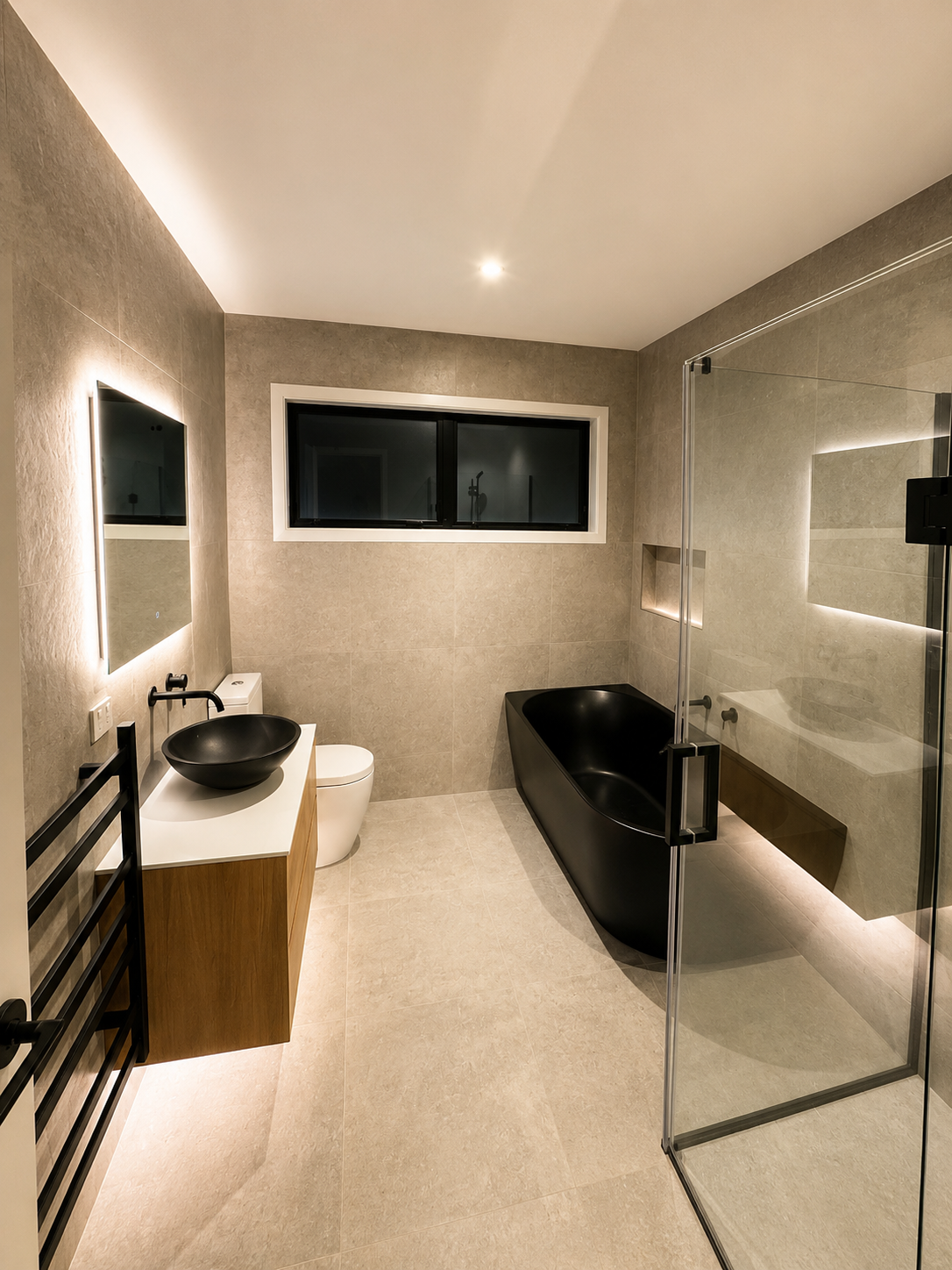 Modern master bathroom with a black freestanding tub, glass shower, and LED-lit mirror in a new Riverhead build.