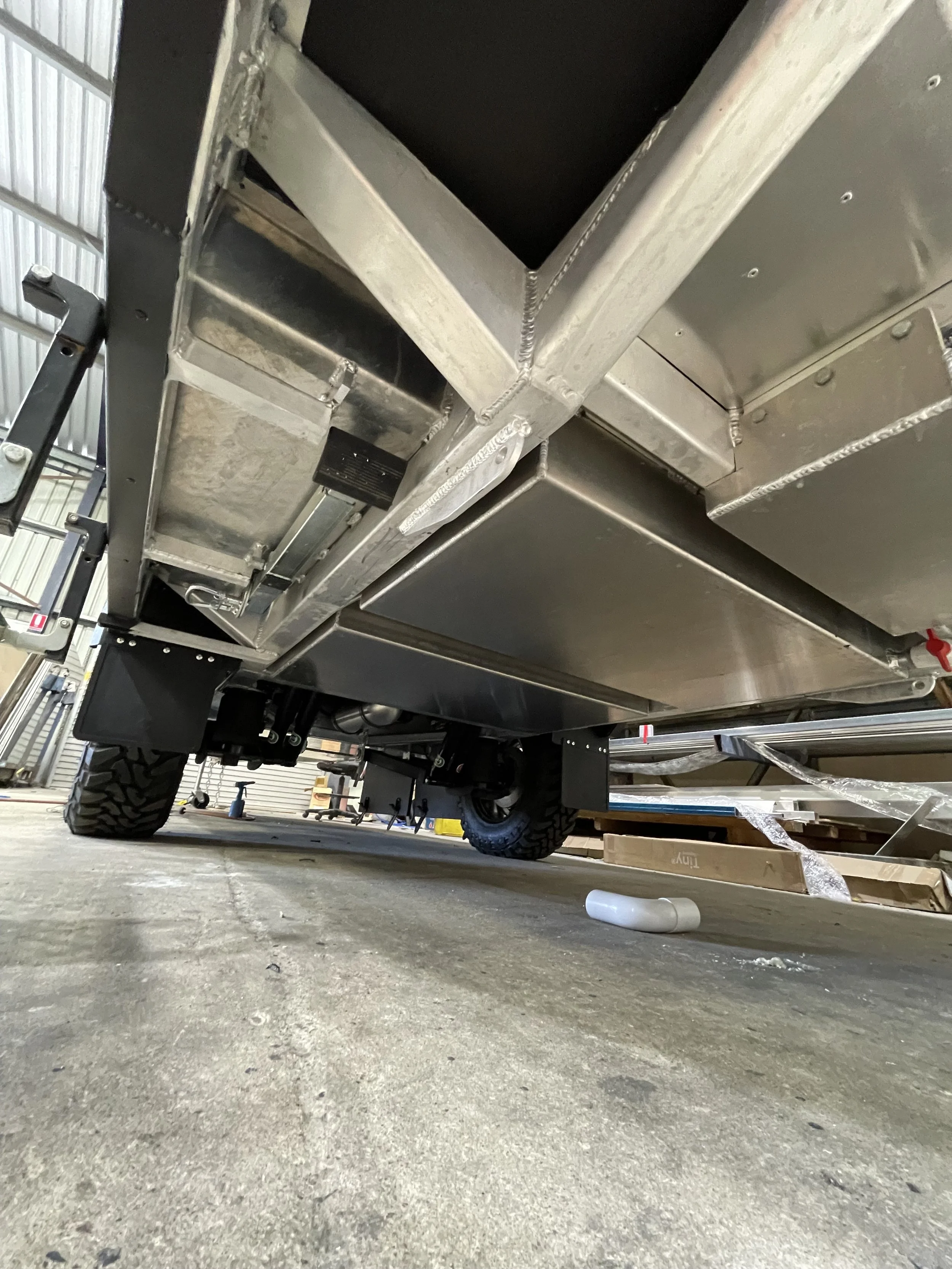 View of the underside of a custom caravan with aluminium chassis and aluminium water tanks. built for offroad travel