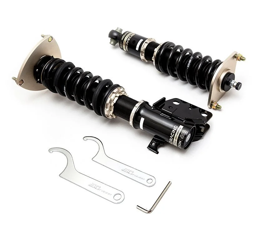 Two car coilover suspension shocks with tools.