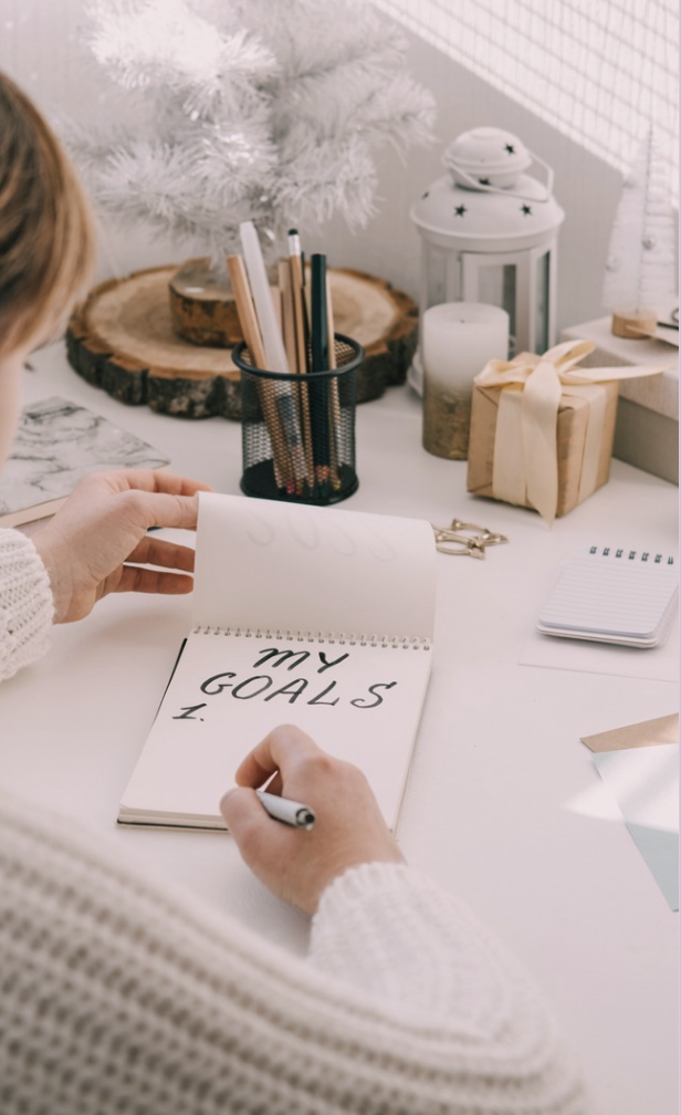 Picture of woman writing her goals.