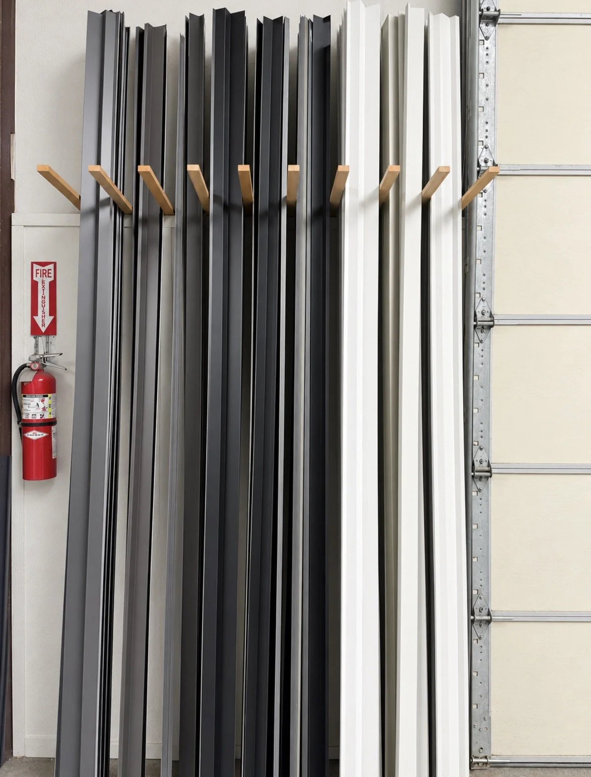 Stack of custom-bent aluminum and steel flashing profiles fabricated for exterior siding, roofing, and trim applications.