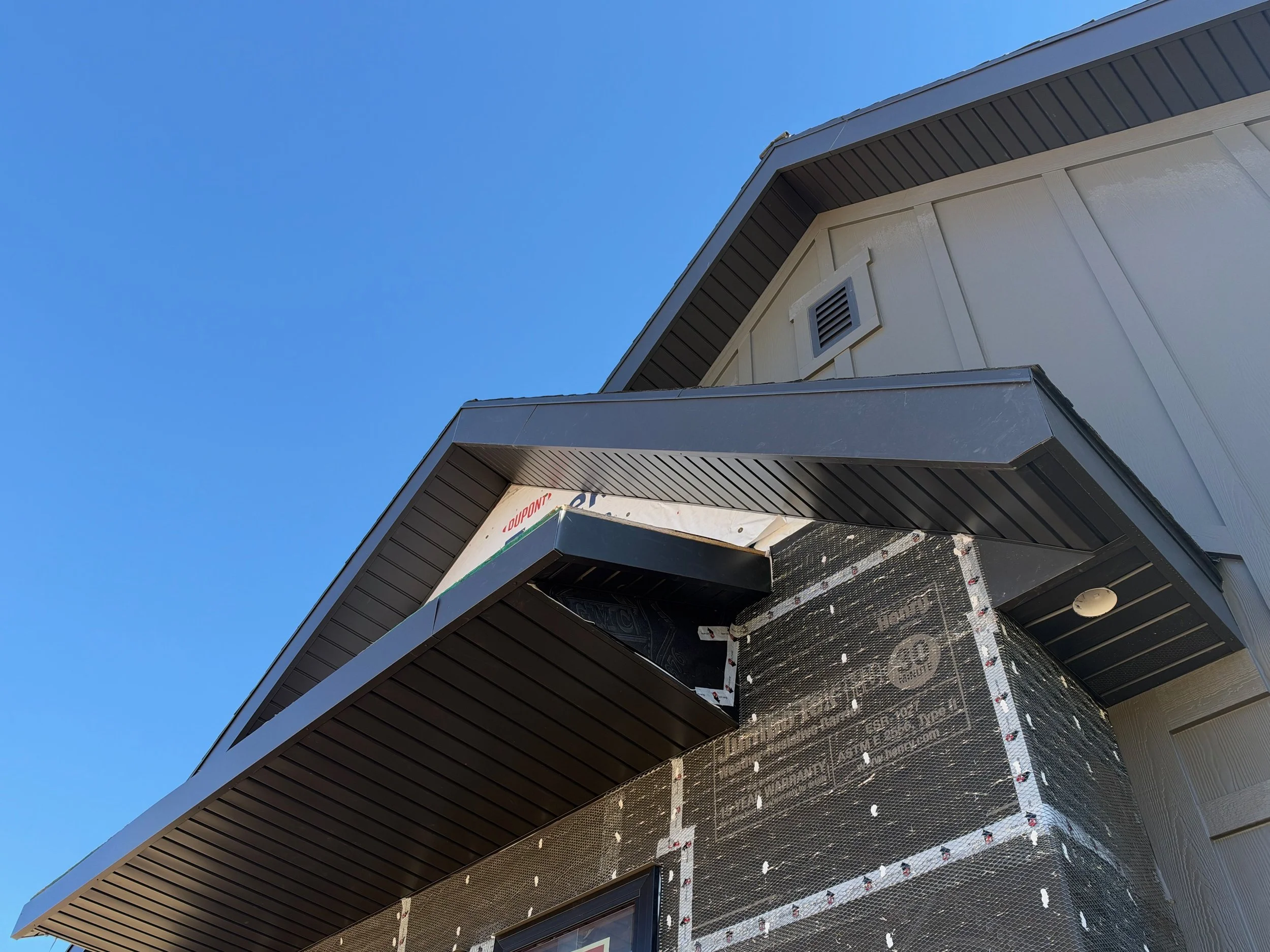 Dark soffit panels installed beneath the gable roof overhang of a two-story home.
