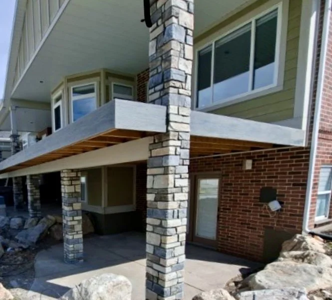 Red brick masonry exterior on a residential building with covered walkways and stone columns