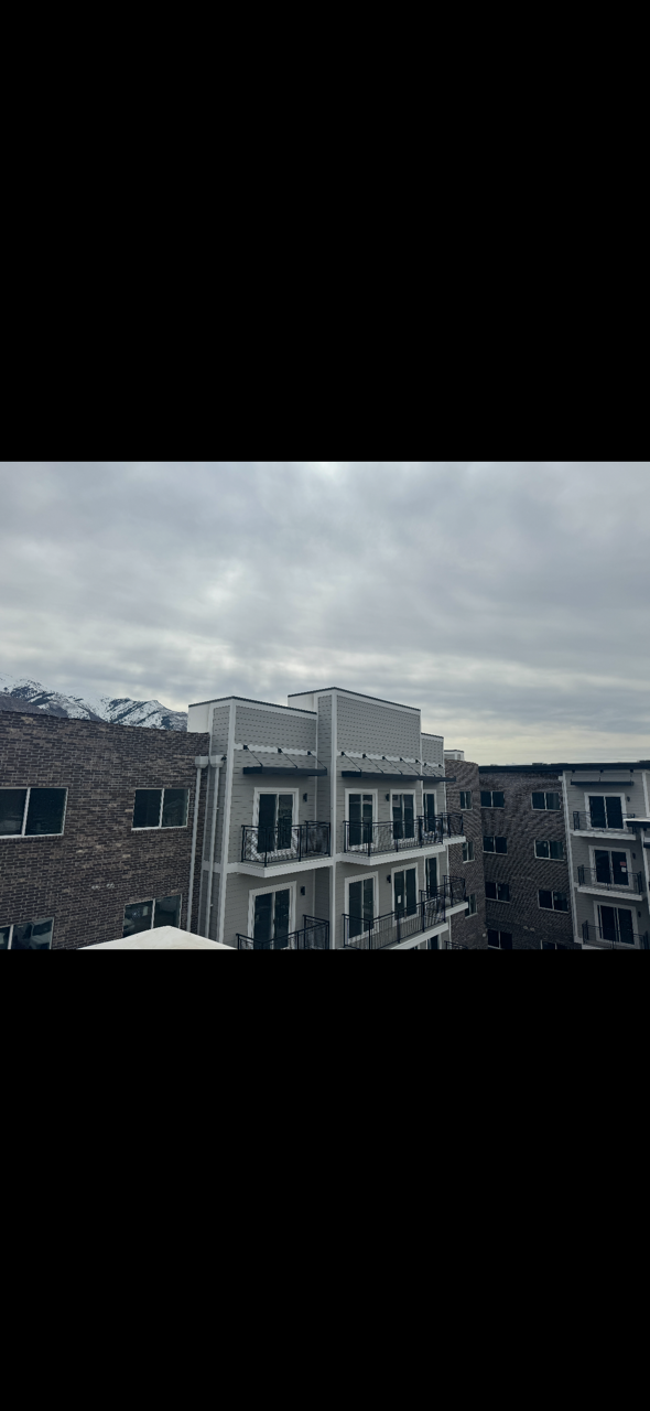 Multi-family residential exterior featuring brick masonry, siding, custom trim, balconies, soffit, and fascia installation.