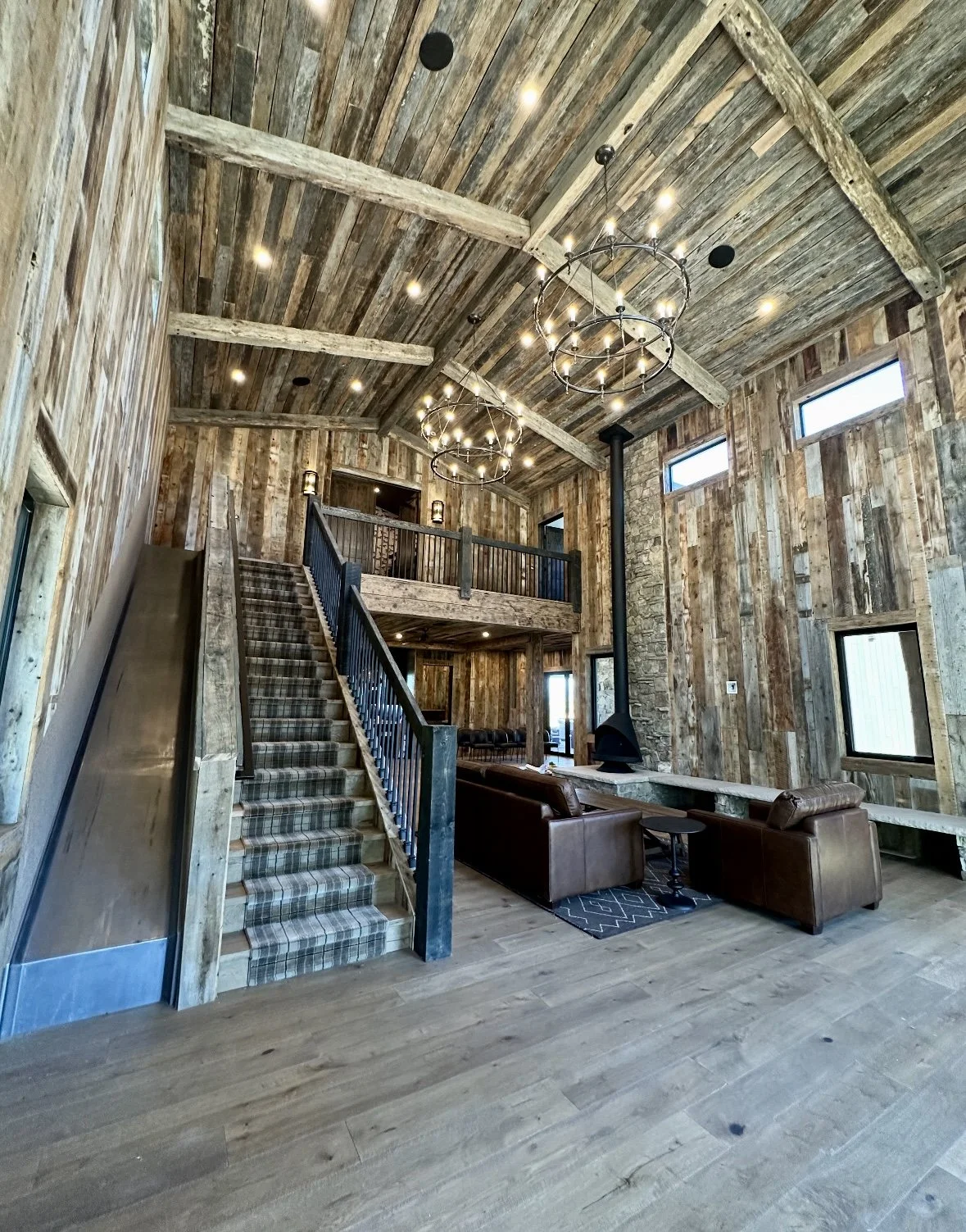 Stained cedar walls and ceiling in a living room space with a slide and stairs