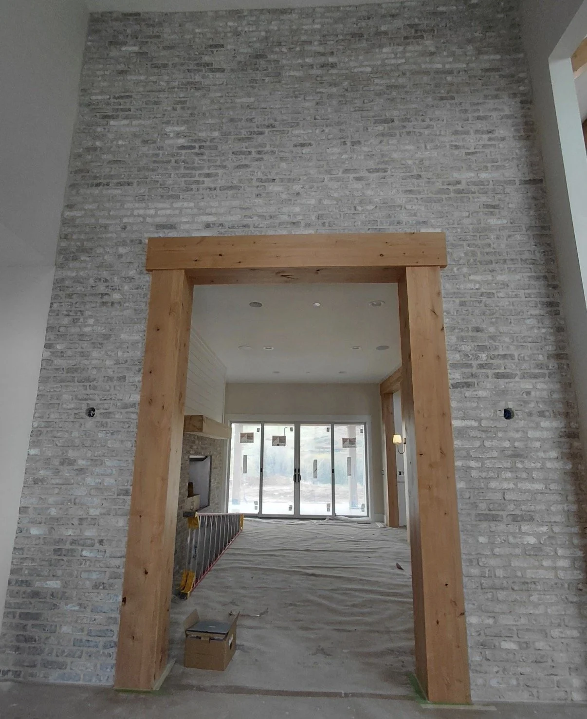 Light gray thin brick veneer accent wall surrounding a wood-trimmed interior doorway