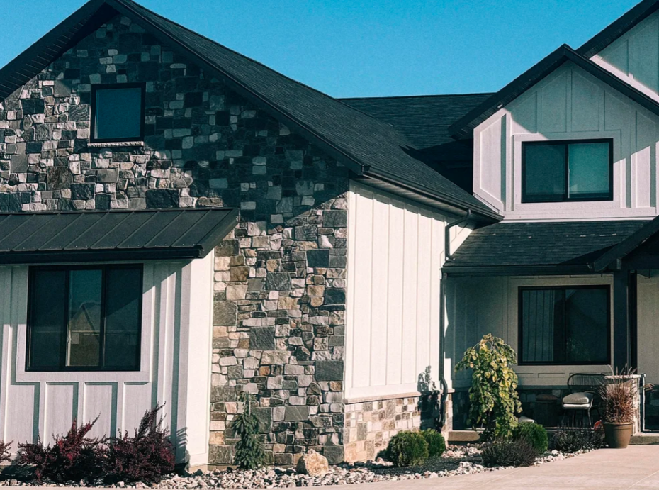 Multicolored natural stone veneer on the front gable and exterior walls of a modern home