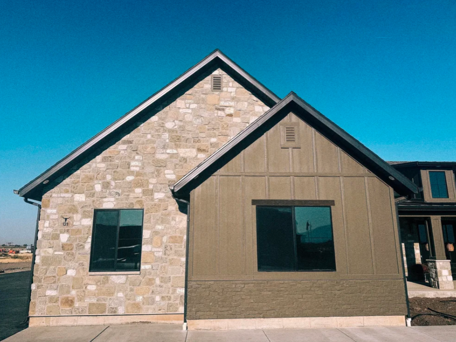 Natural stone veneer exterior on a home with multiple gables and dark-framed windows