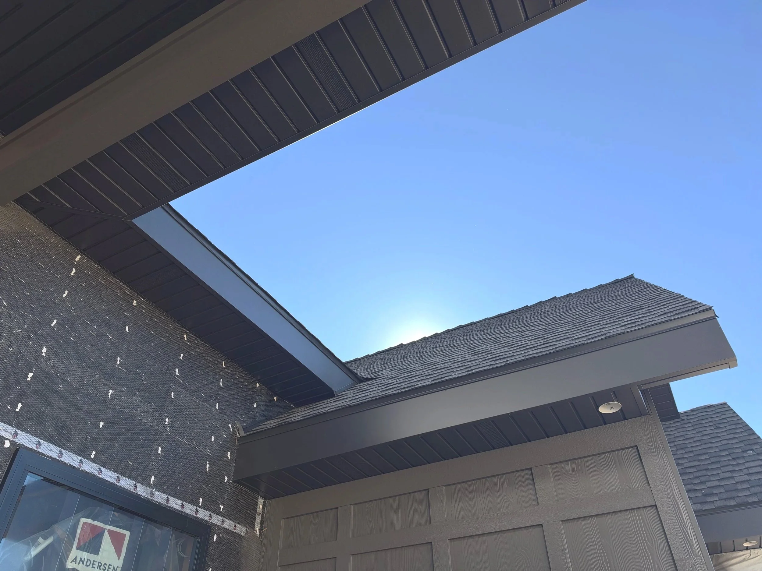 Gray soffit panels installed beneath a modern home's roof overhang with recessed lighting.