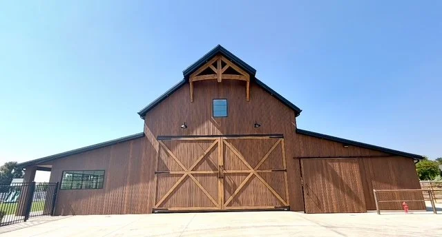 Rustic barn featuring natural wood exterior siding, decorative crossbuck barn doors, and exposed timber gable accents.
